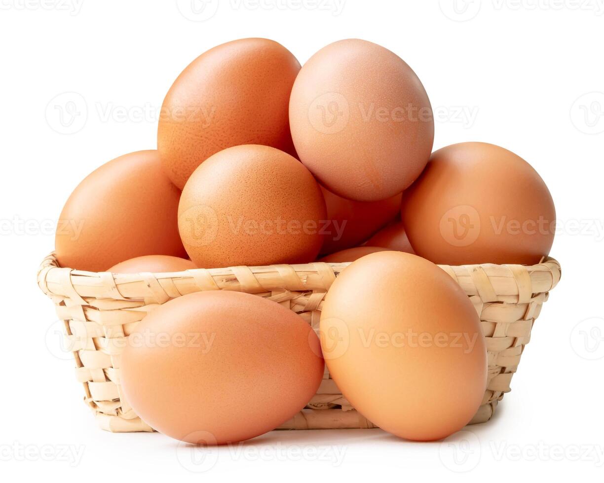 Group of fresh brown chicken eggs in stack in wicker basket isolated on white background with clipping path photo
