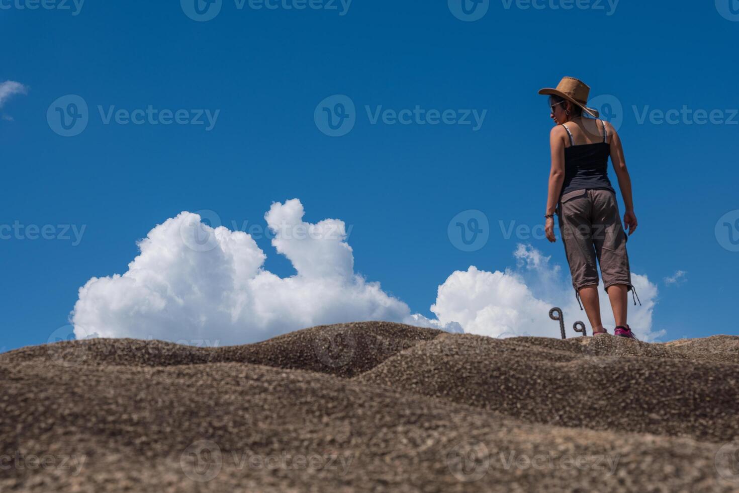 A traveler looks out over the landscape from atop a rock in the Peruvian jungle. photo