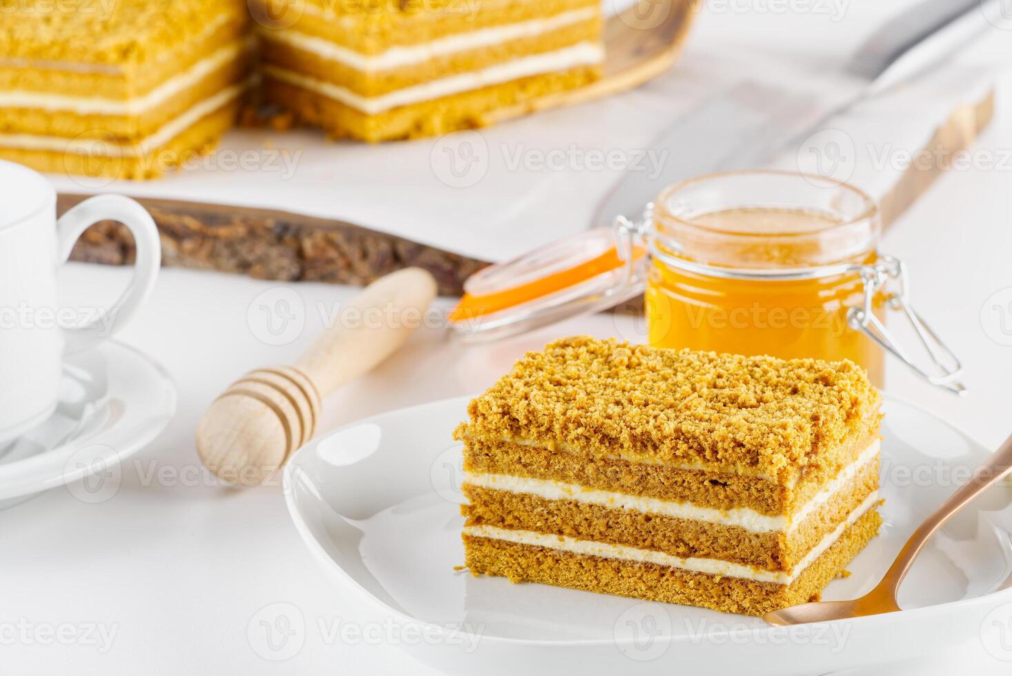 Homemade Honey cake. Honey cake Medovik, layer cake on white plate. Closeup view. sweet dessert cake. Slice of layered honey cake selective focus. photo