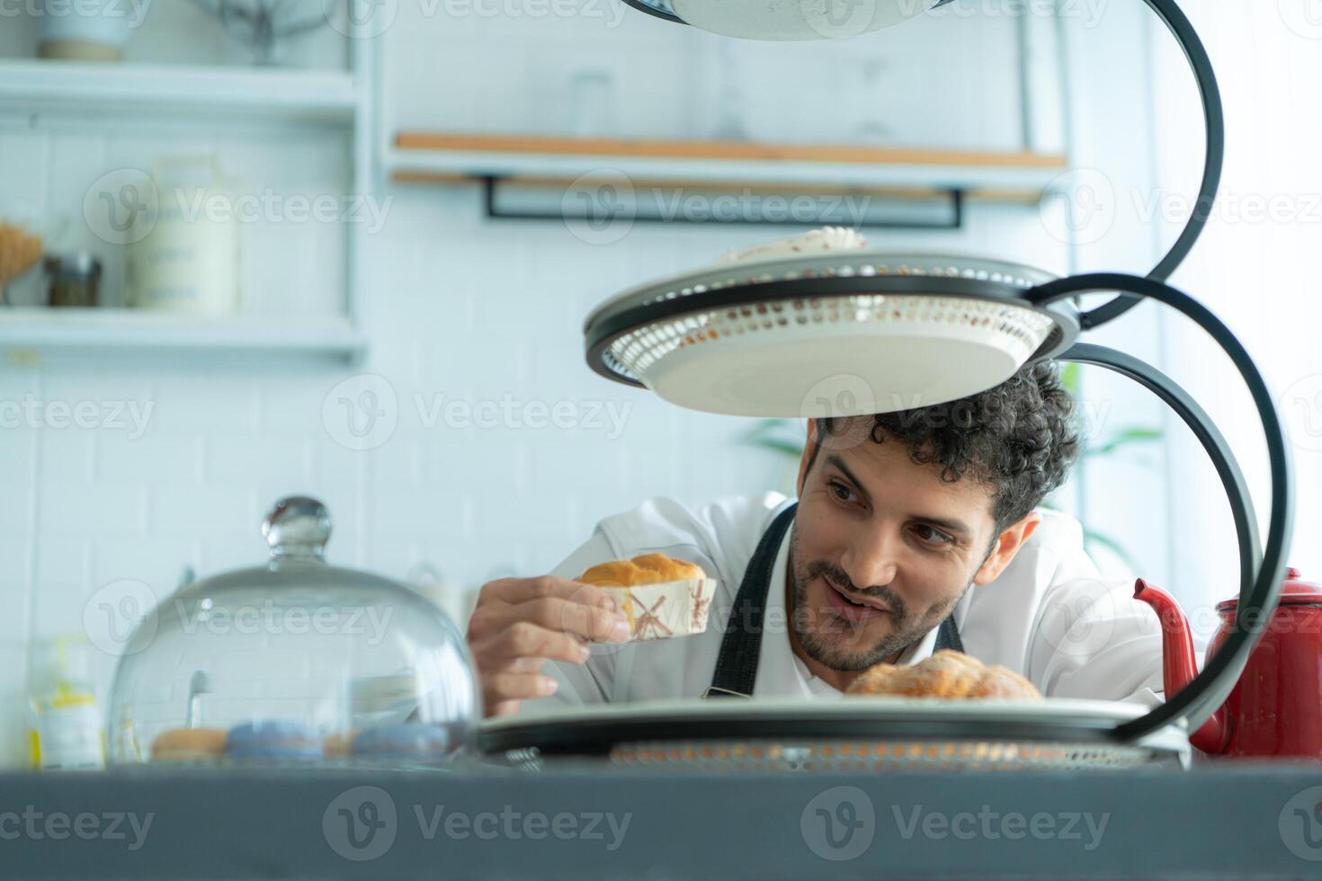 A young man puts on an apron to make dessert to eat with his wife. Checking the completeness of the finished dessert. photo