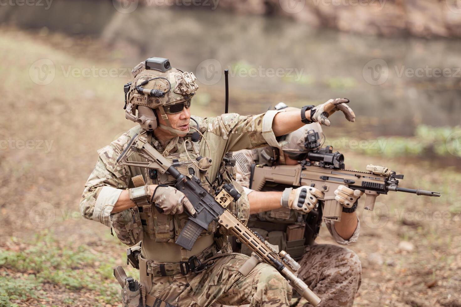 Soldiers in camouflage military uniforms carrying weapons, Reconnaissance missions in the tropical forest area, Assault infantry battle training. photo