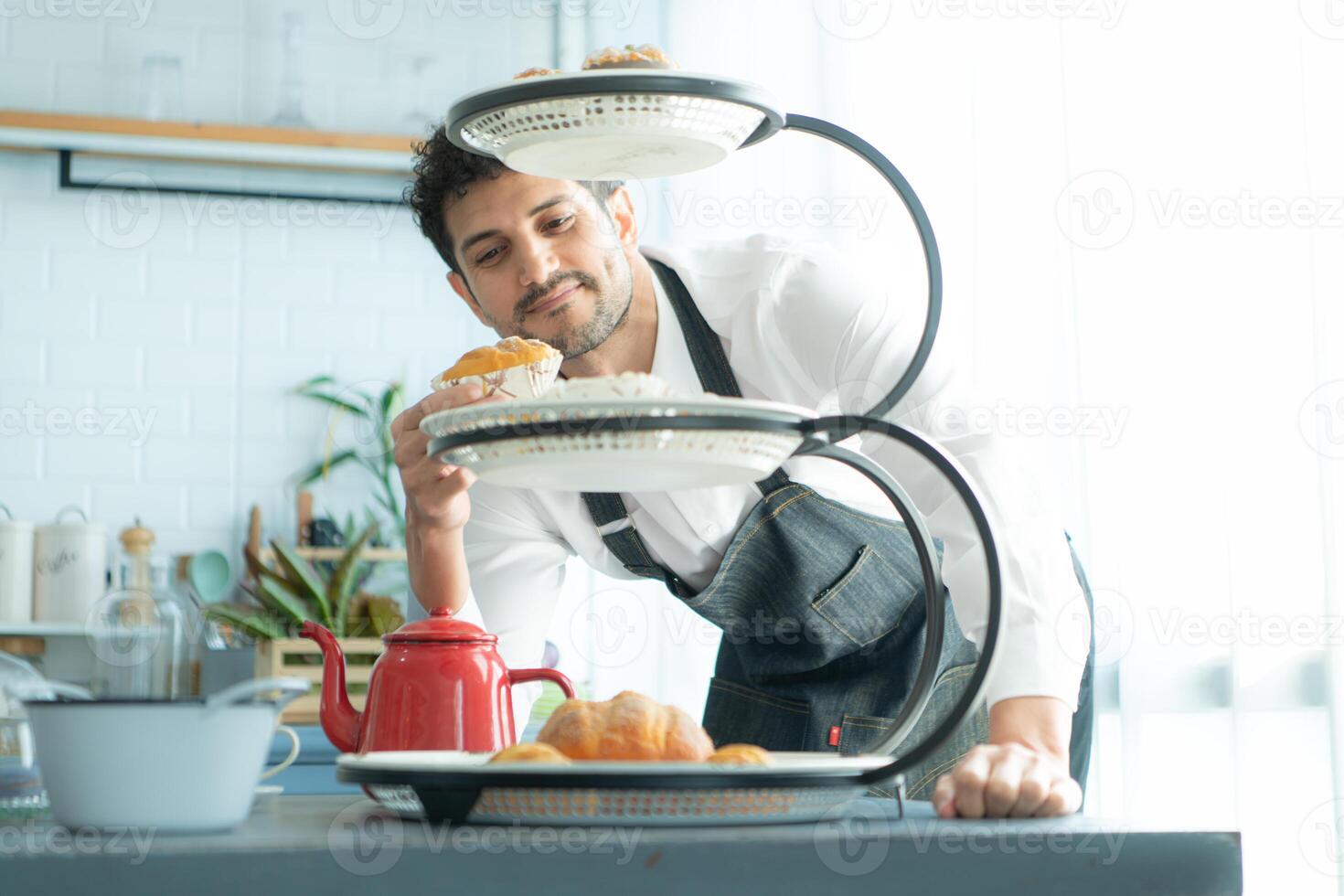 A young man puts on an apron to make dessert to eat with his wife. Checking the completeness of the finished dessert. photo