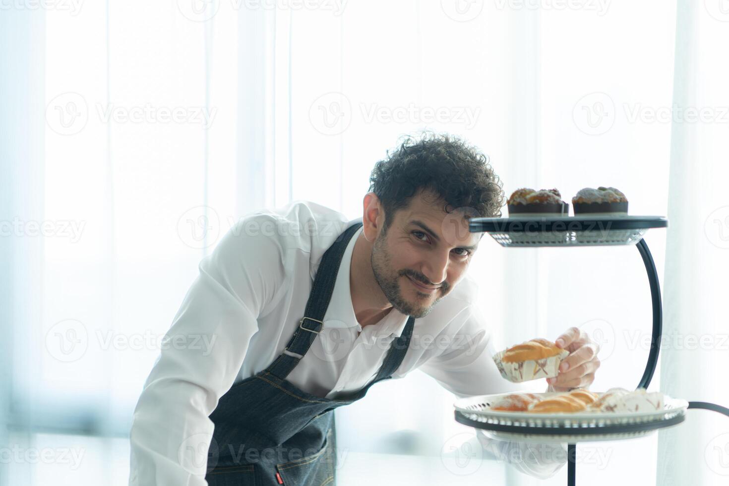 A young man puts on an apron to make dessert to eat with his wife. Checking the completeness of the finished dessert. photo