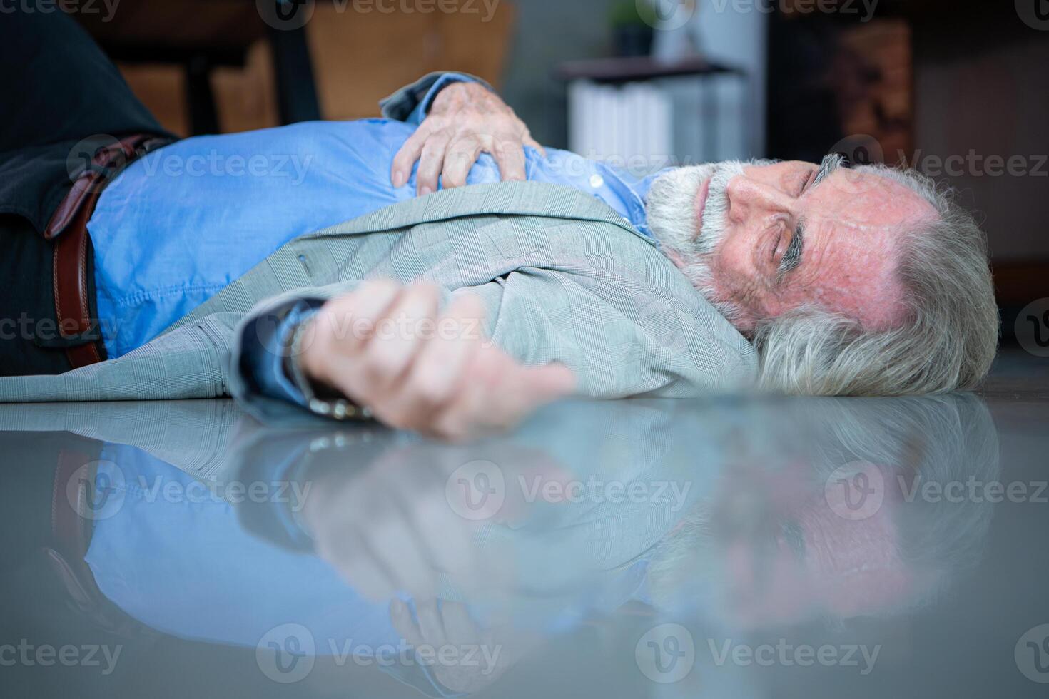 An elderly businessman fell to the floor with sudden heart failure at work photo
