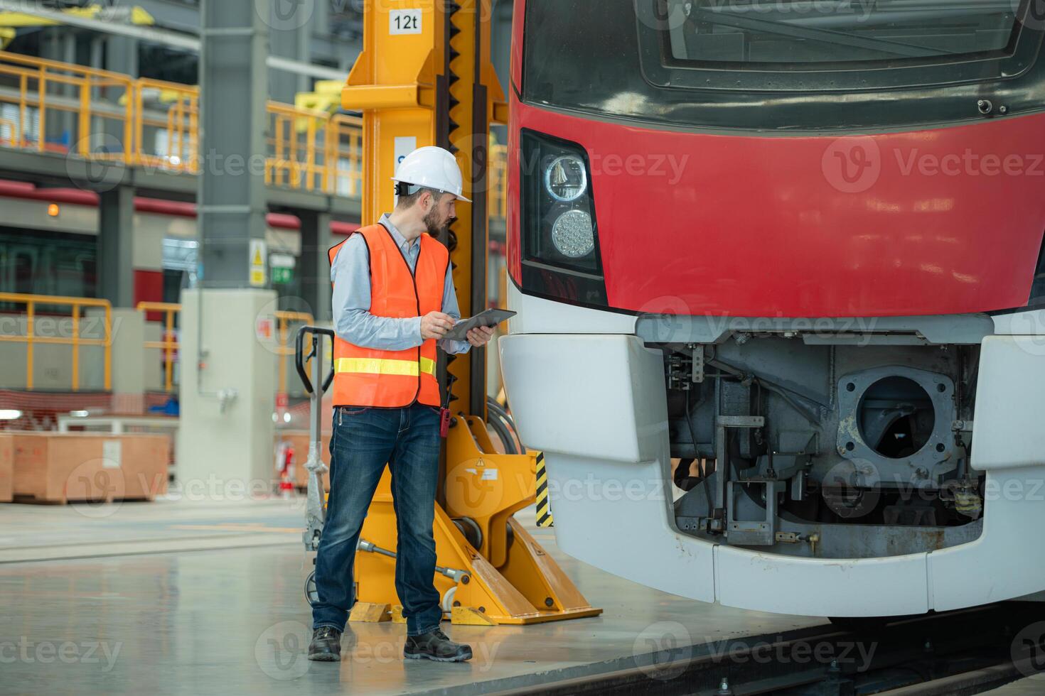 Portrait of a young male technician using a tablet working and standing in a skytrain repair station. photo