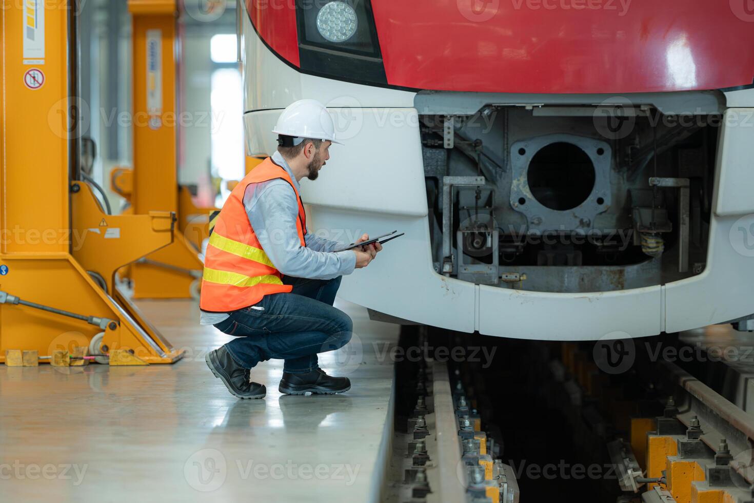 Portrait of a young male technician using a tablet working and standing in a skytrain repair station. photo