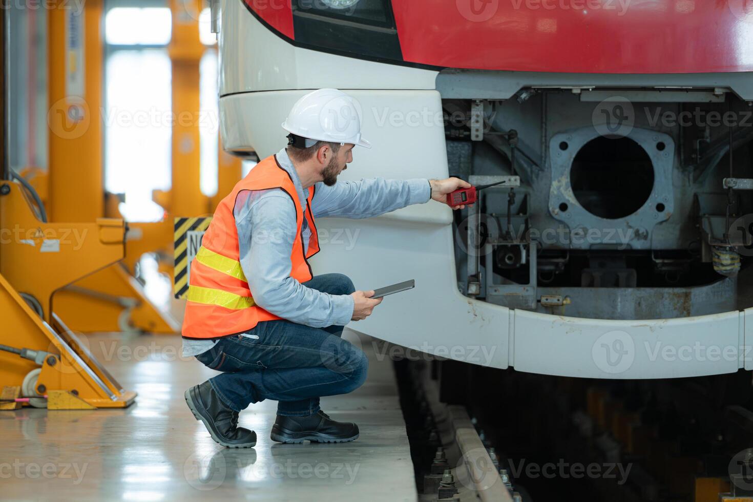 Portrait of a young male technician using a tablet working and standing in a skytrain repair station. photo