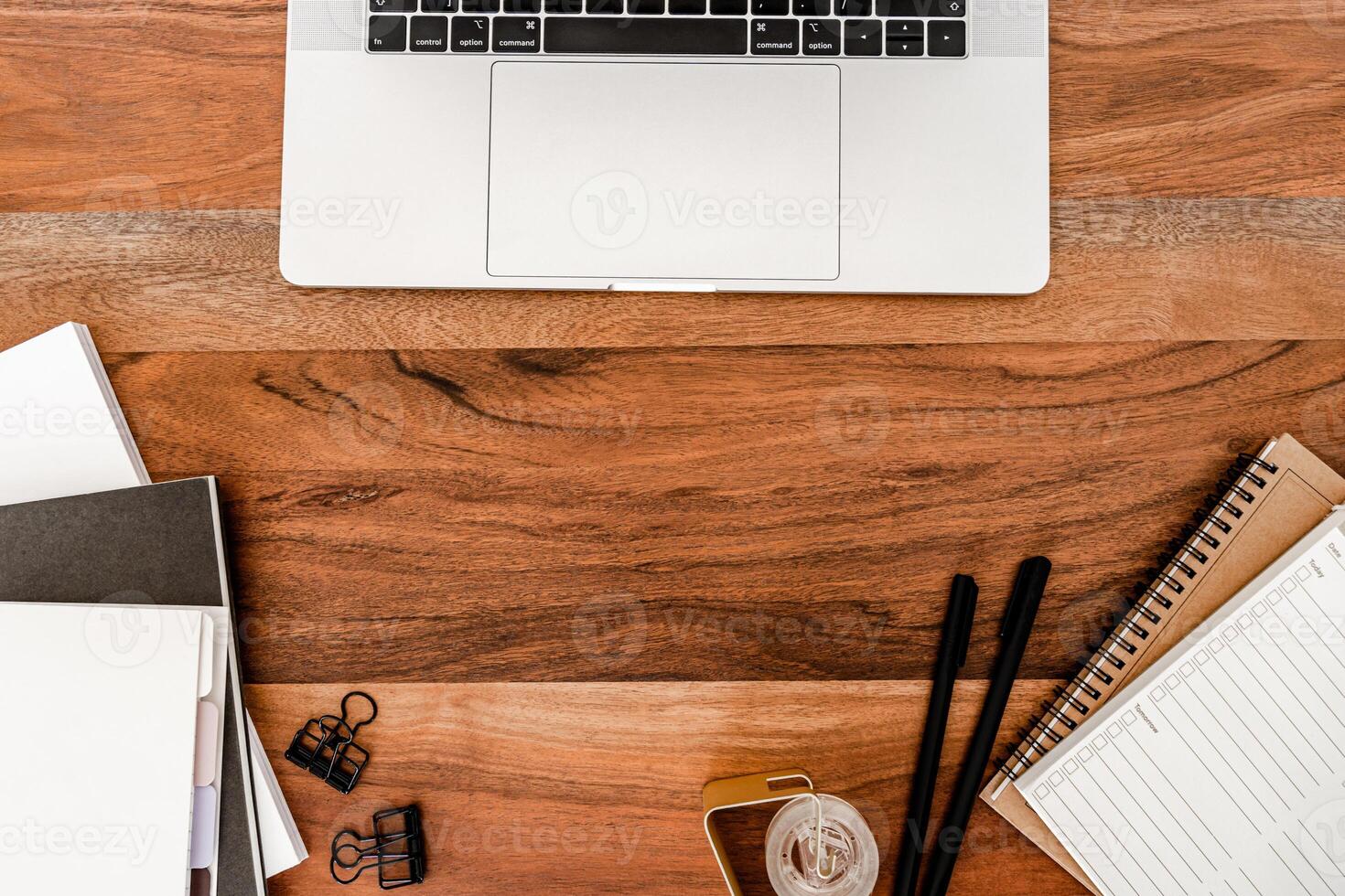 Wood desk office copy space with laptop, stationery and notepads flat lay photo