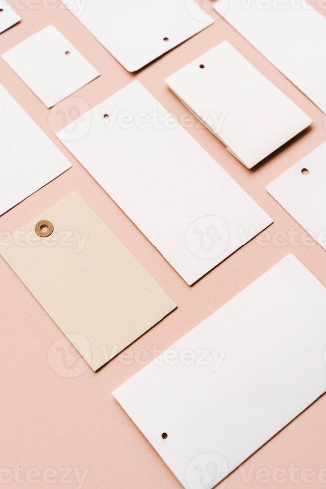 White price labels, blank tags with different shapes and sizes on a beige background. photo