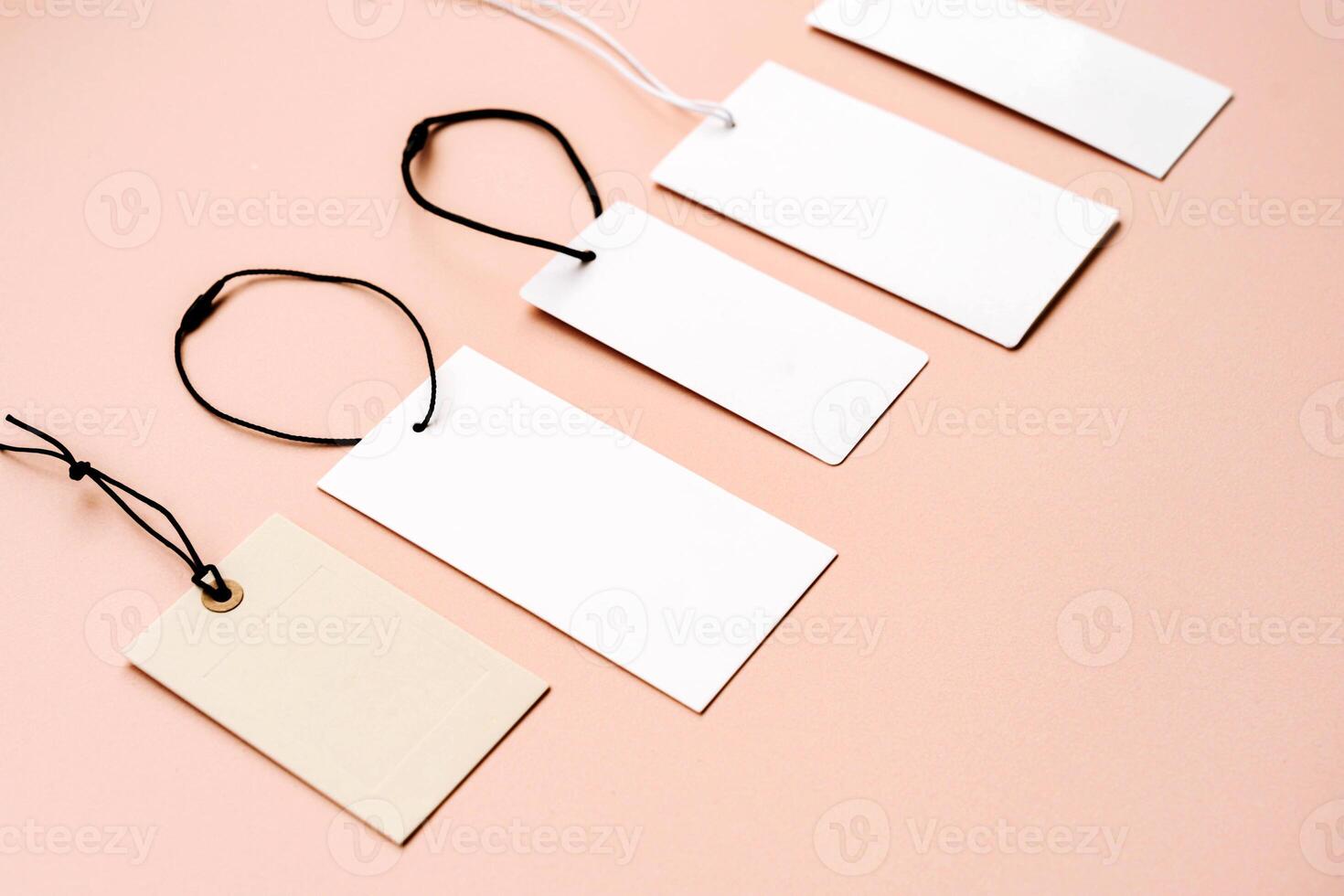 White price labels, blank tags with different shapes and sizes on a beige background. photo