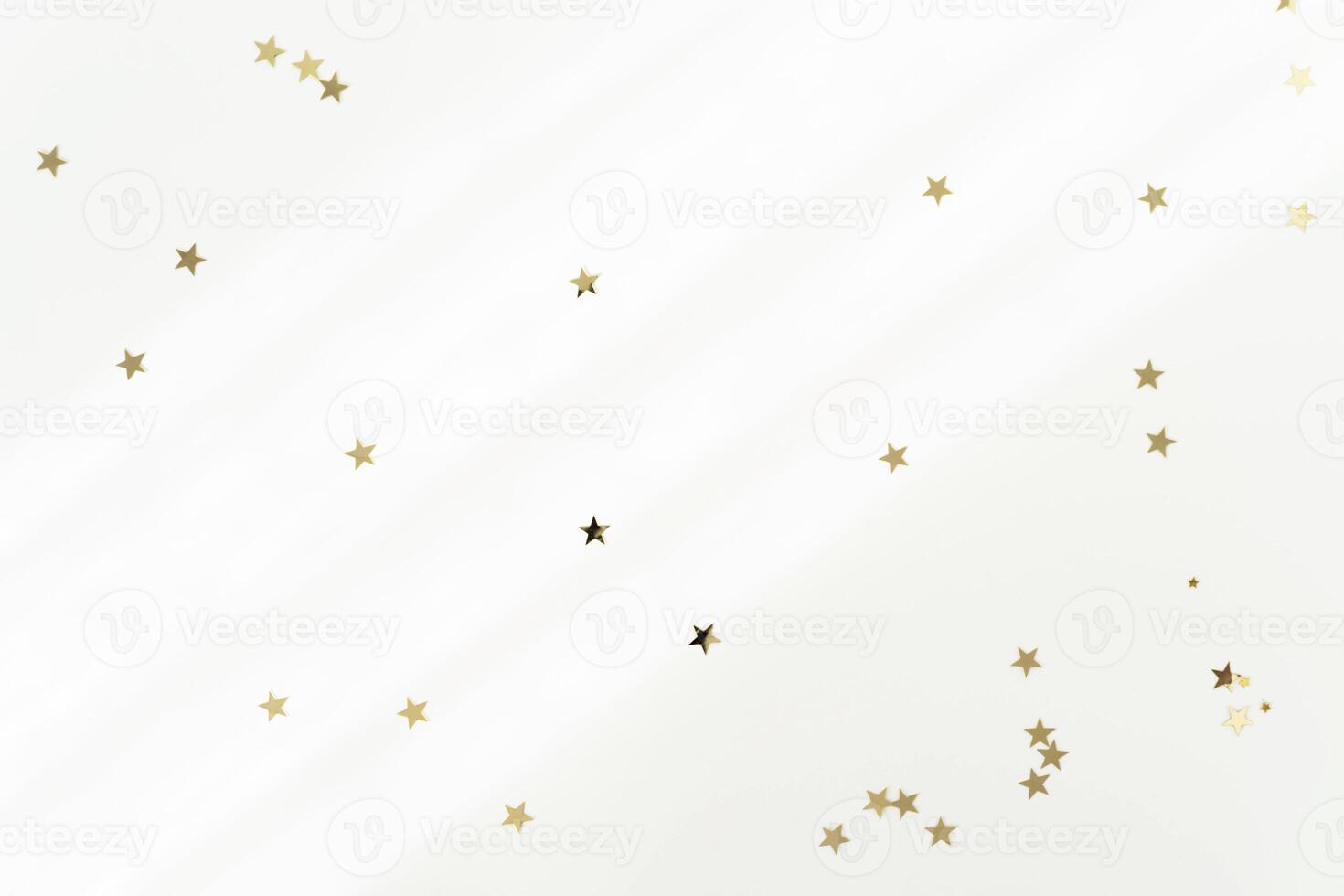 Gold stars on a light pastel background with diagonal shadows. photo