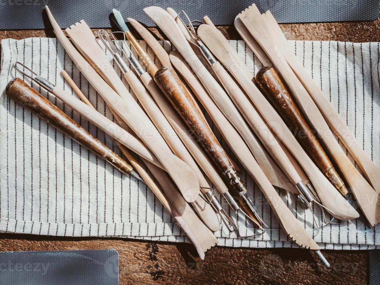 Set of clay modeling tools on white napkin background on wood table photo