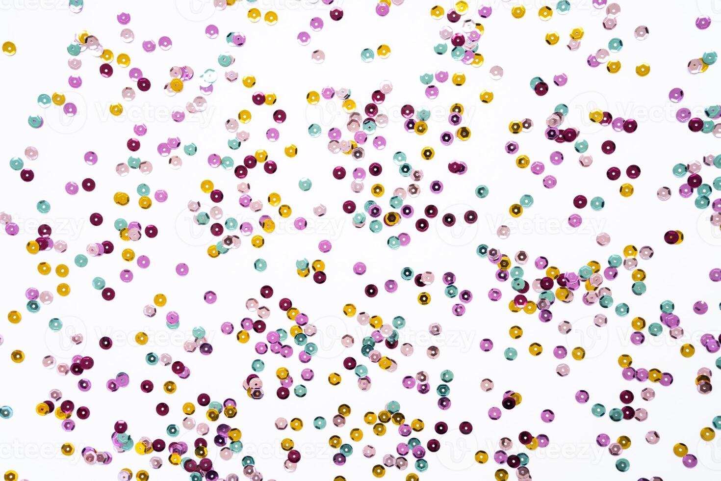 Various colored sequins on a white background. photo