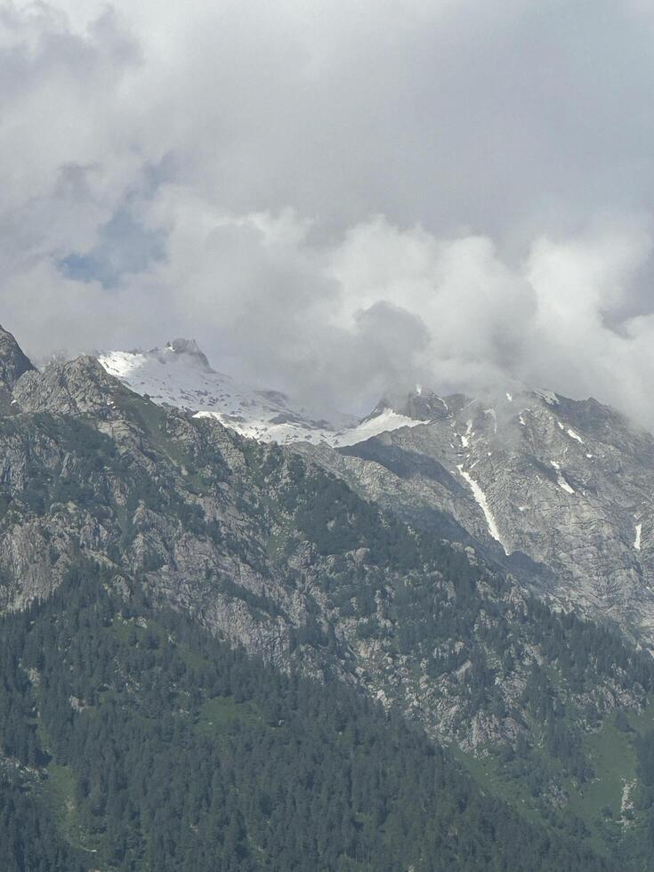 A plane flying over a mountain range with snow capped peaks photo