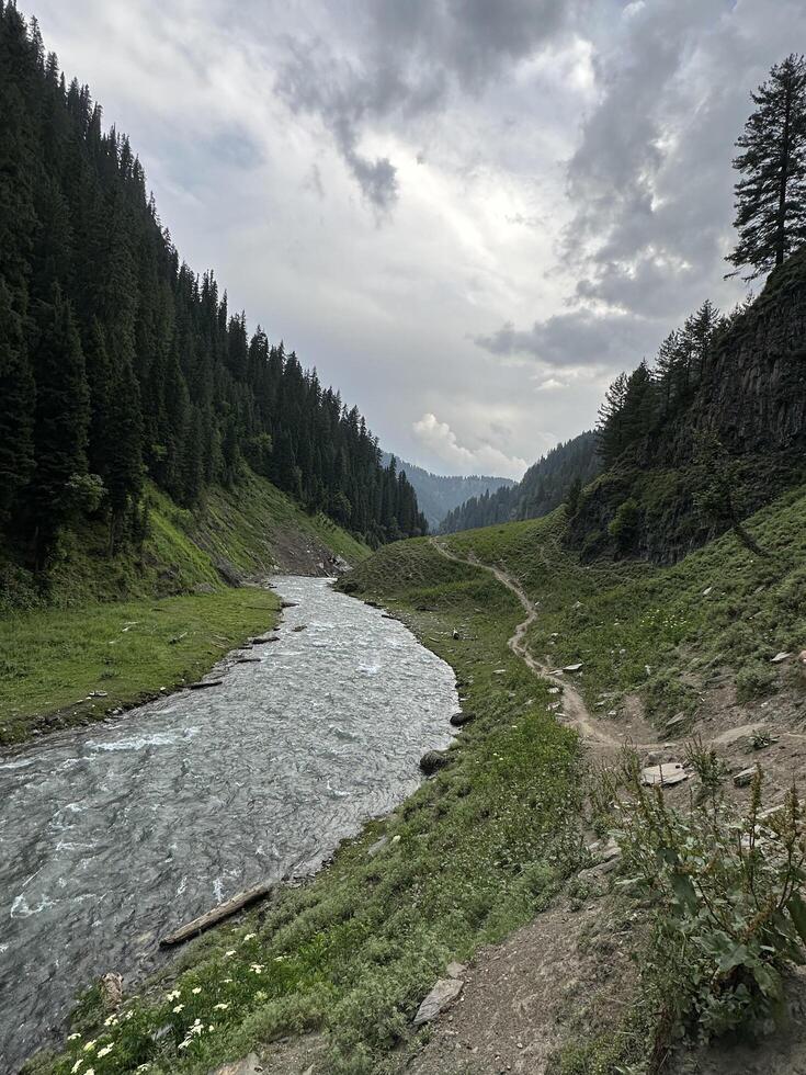 A river runs through a valley surrounded by mountains photo