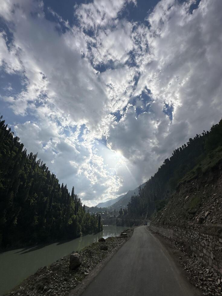 A road with a river and mountains in the background photo