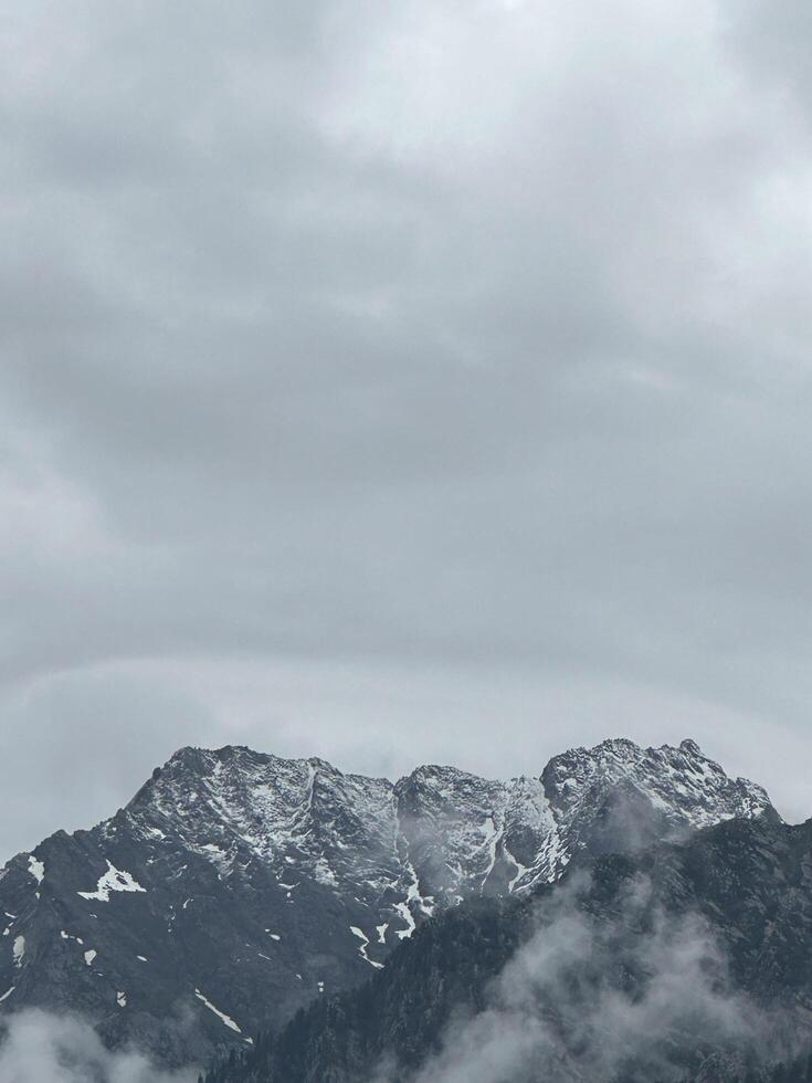 A plane flying over a mountain range with clouds photo