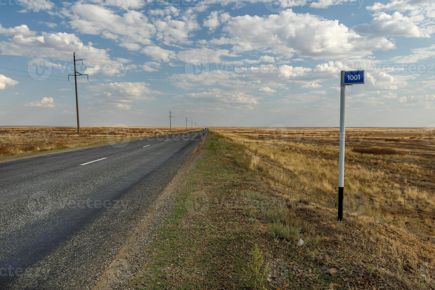 empty road in the steppe and kilometer sign 1001 photo