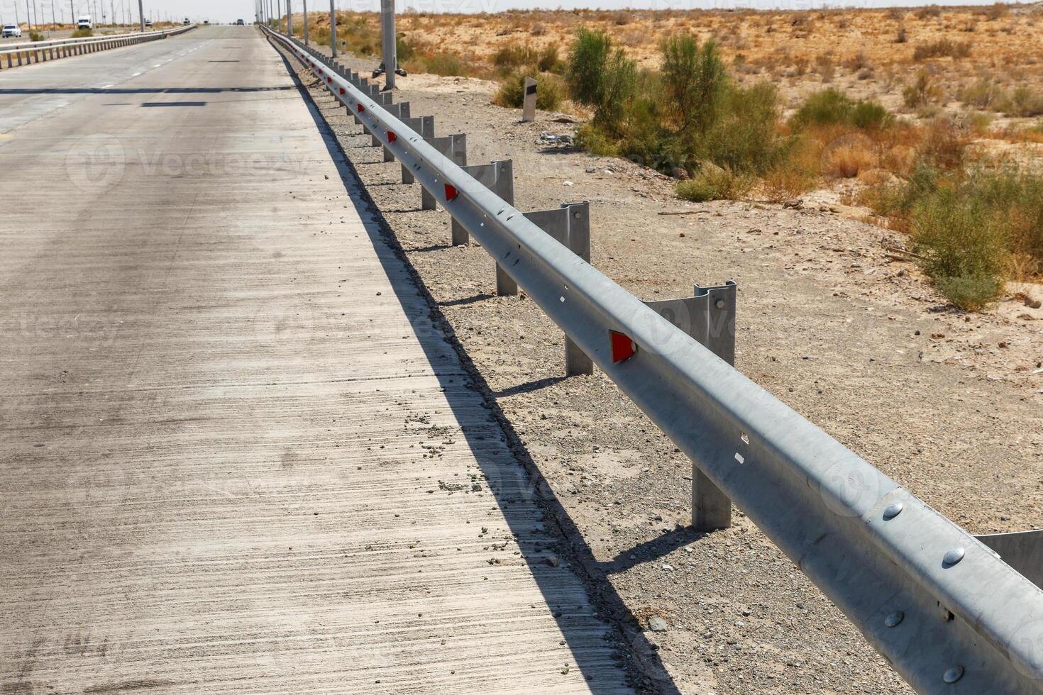 Fencing along the road on concrete pavement in a dry landscape. Uzbekistan photo