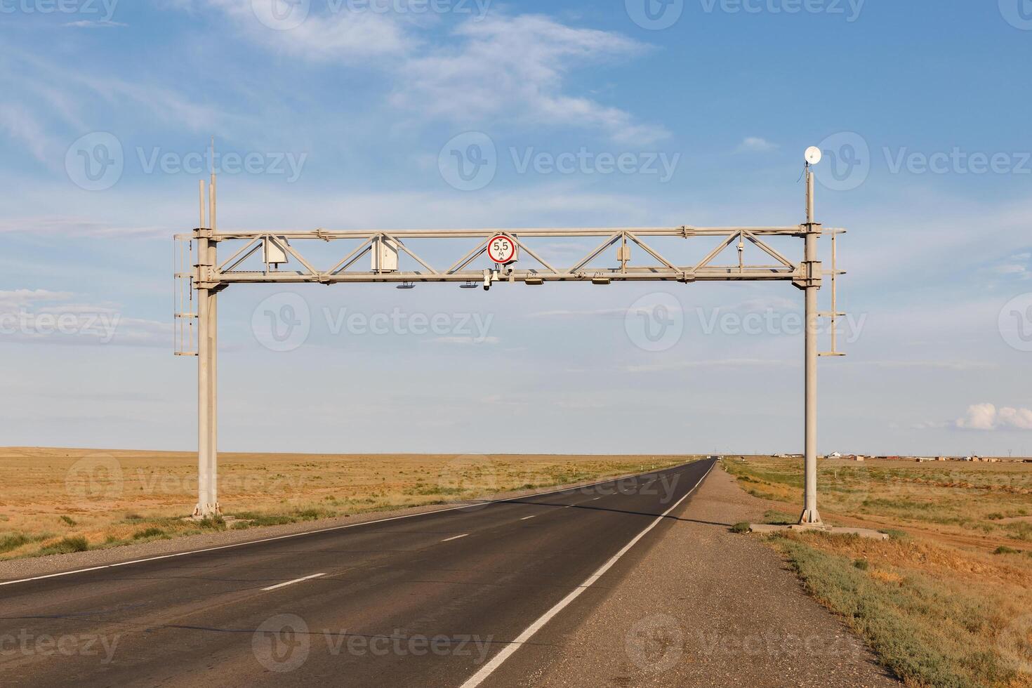 Road sign and warning signal over an empty highway in Kazakhstan's vast steppe region photo