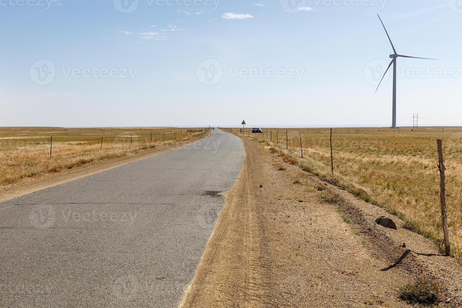 asphalt road in the steppe with wind generator on the horizon, Inner Mongolia photo