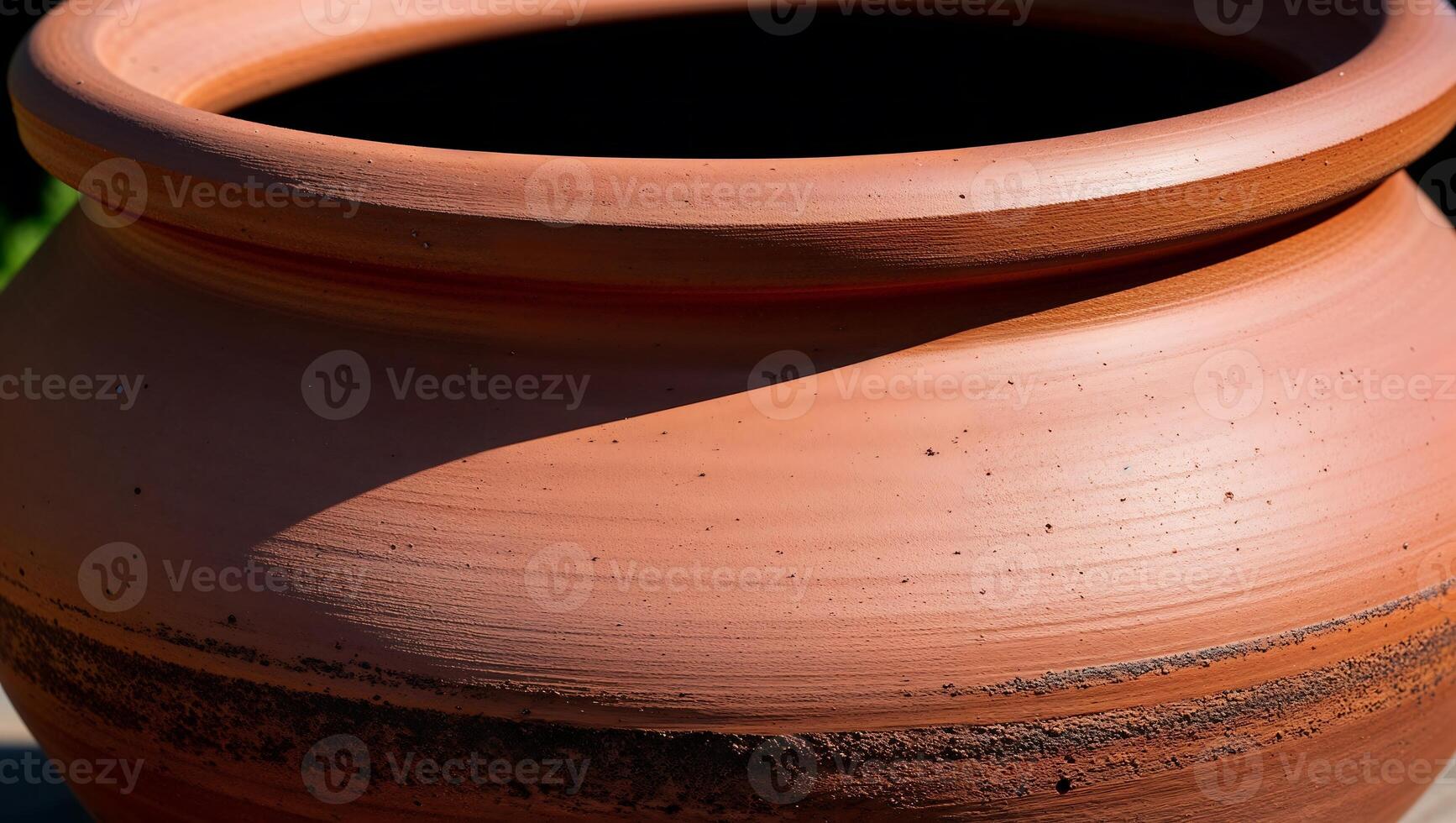A large clay pot sitting on a wooden surface photo