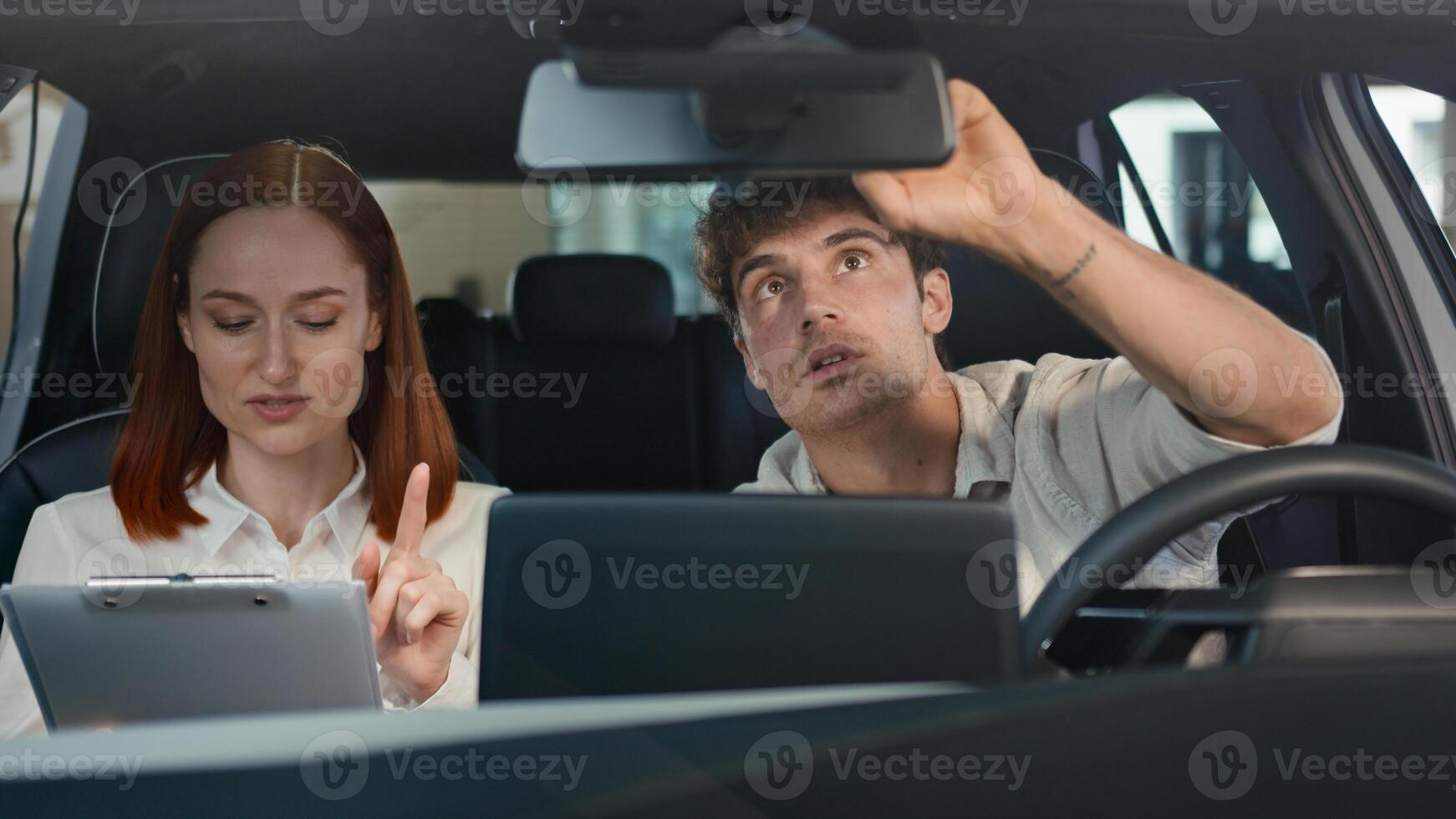 Caucasian man buyer client choosing try new car test drive service buying automobile talking sitting inside auto salon with seller woman manager trader saleswoman consultation trade rental transport photo