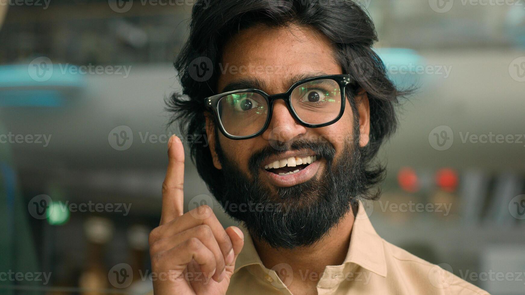 Thoughtful Arabian businessman thinking of business challenge rise finger come up with idea. Pensive Indian bearded man in glasses lost in thoughts think happy with solving problem insight gesture photo