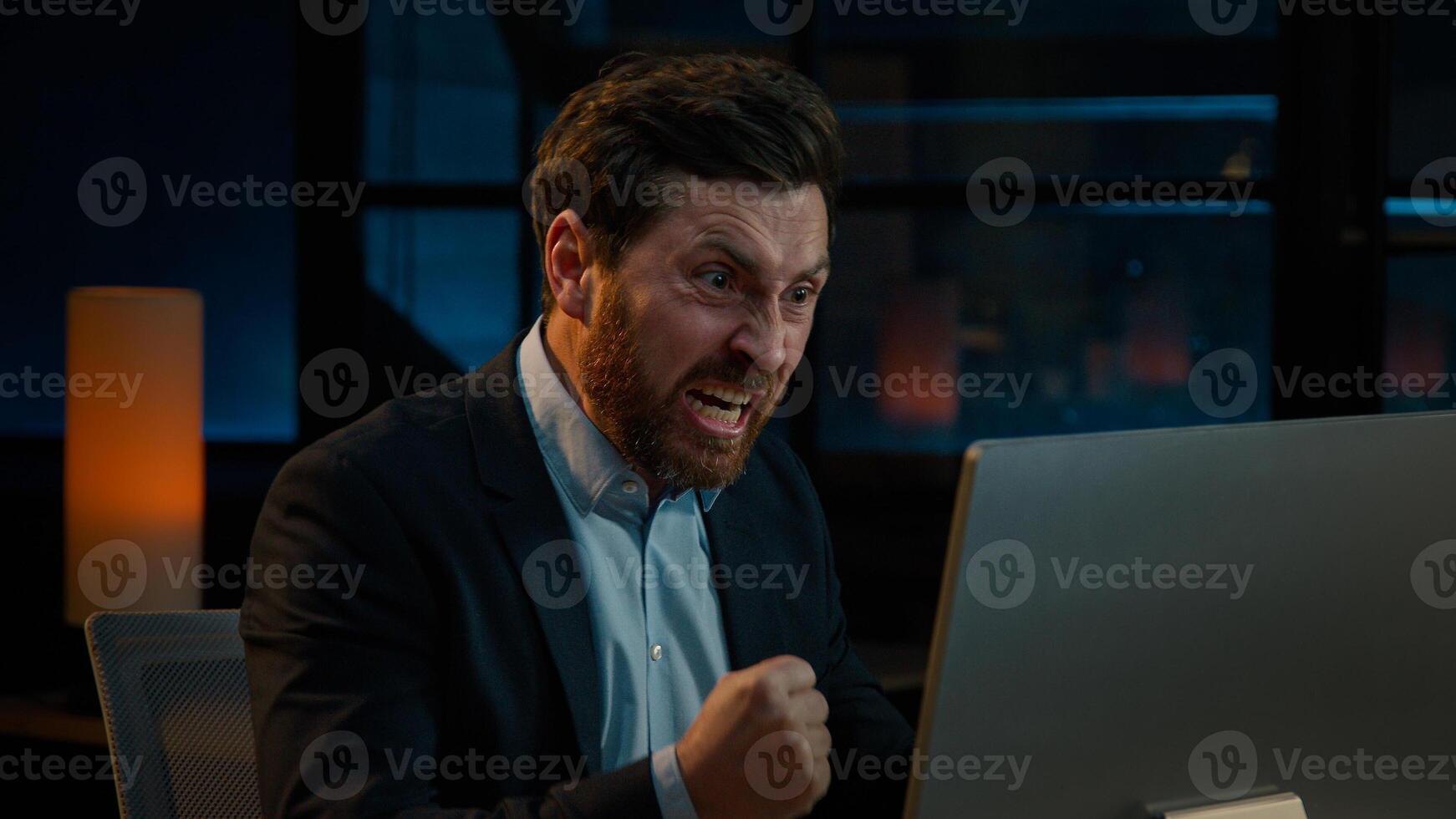 Annoyed angry businessman Caucasian middle-aged 40s man CEO employee mad furious crazy shouting fail online business project on computer trouble failure problem stress evening night office background photo