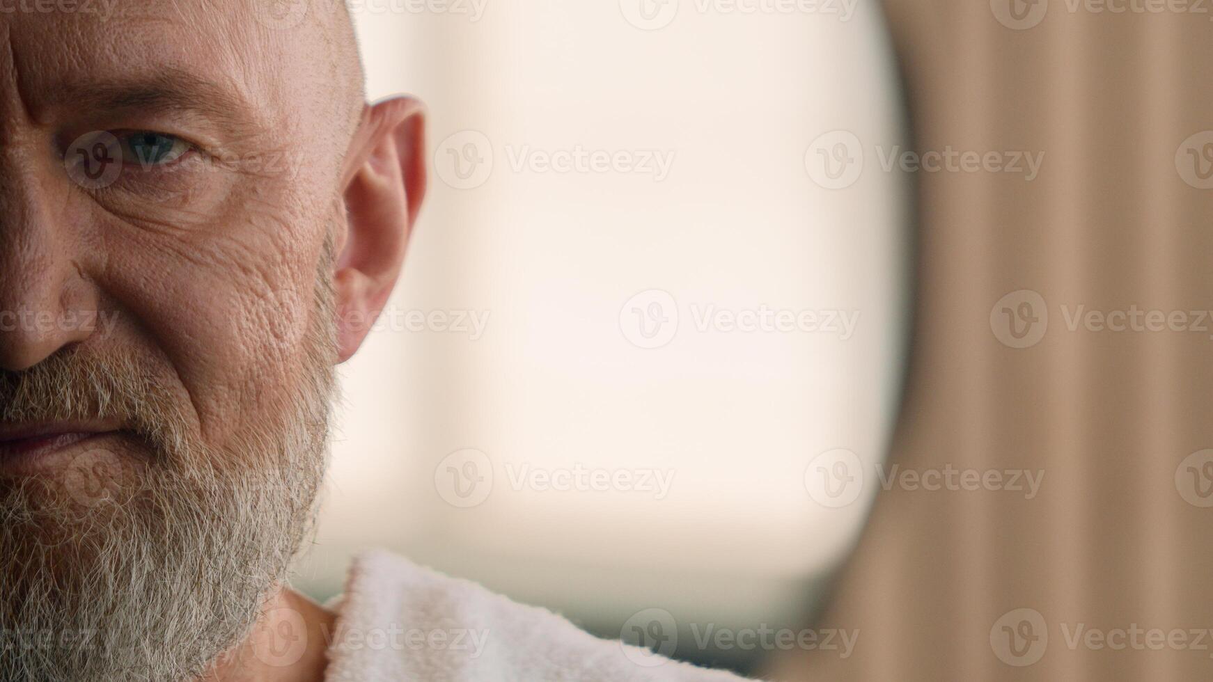 Close up half of male wrinkled face eye problem vision eyesight 70s age wrinkle healthy elderly gray hair bearded man healthcare mature senior old male skin care hygiene beauty bath towel on shoulder photo