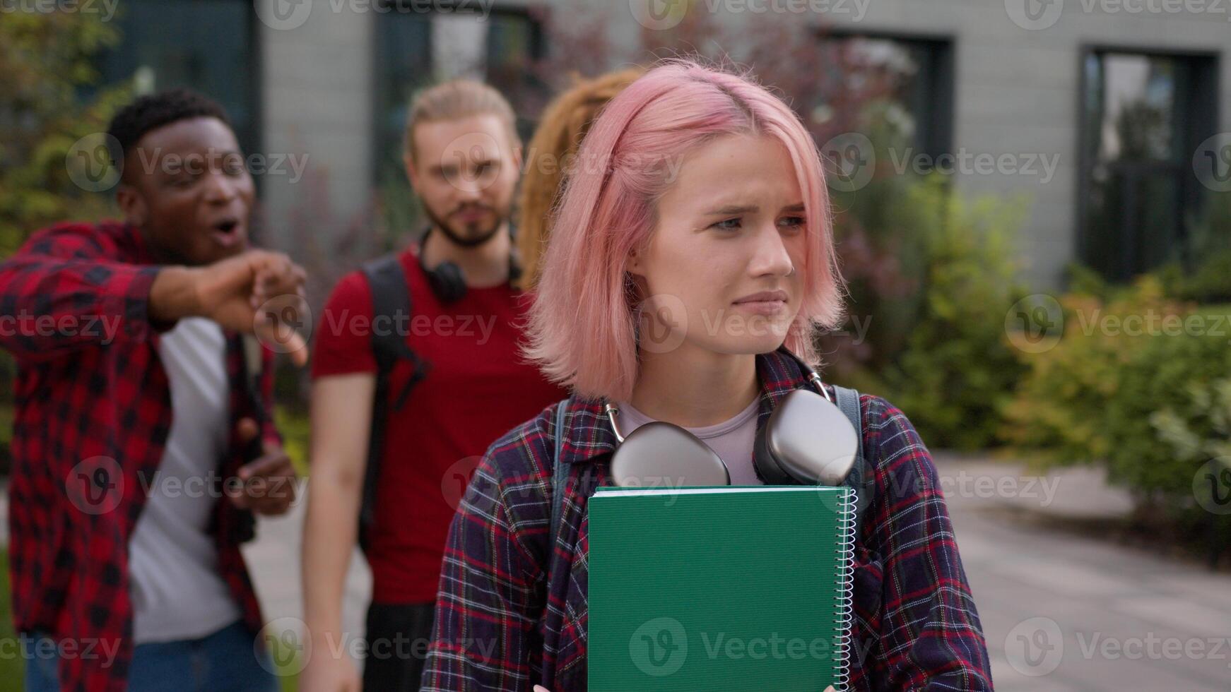 Group multiracial students teens classmates showing thumb down mock abused humiliate bully Caucasian student woman bullied sad upset victim girl mockery high school bullying university college cruel photo