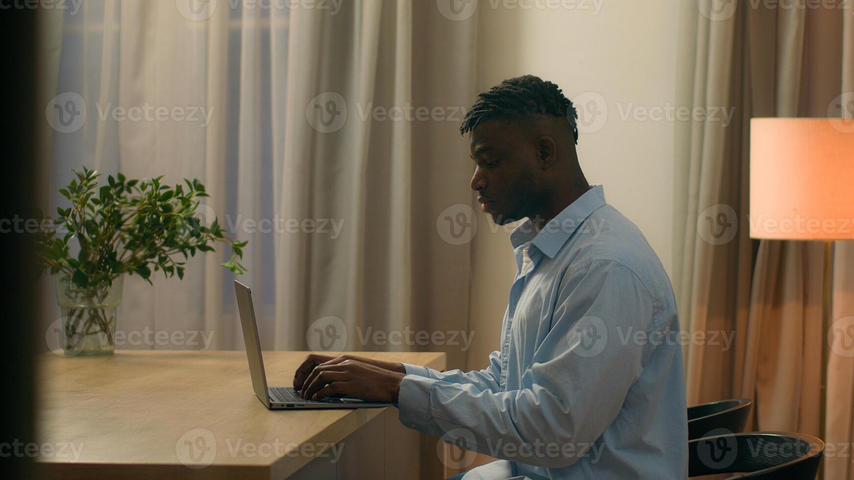 Pensive African American man think idea thinking ponder solution ethnic male biracial guy student business freelancer businessman at evening at home working with laptop computer study typing pc online photo