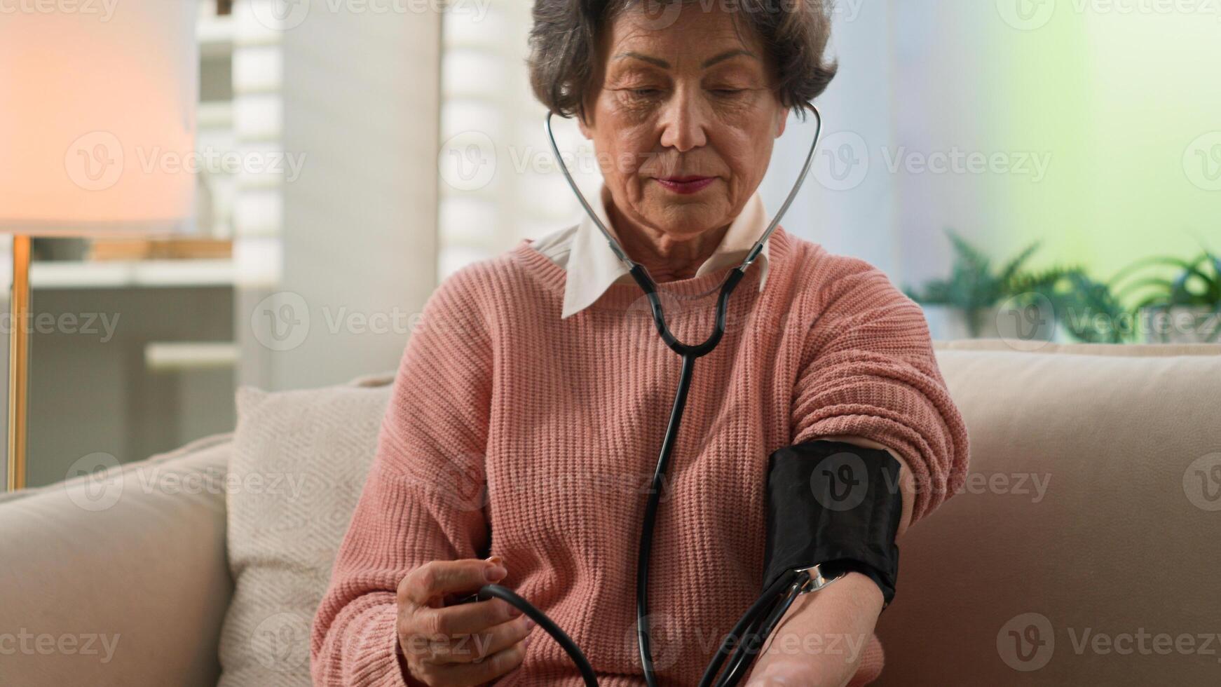 Caucasian grandmother checking low high cardio heart beat senior woman at home old female granny elderly retired lady using portable medical device use digital measuring check blood pressure health photo