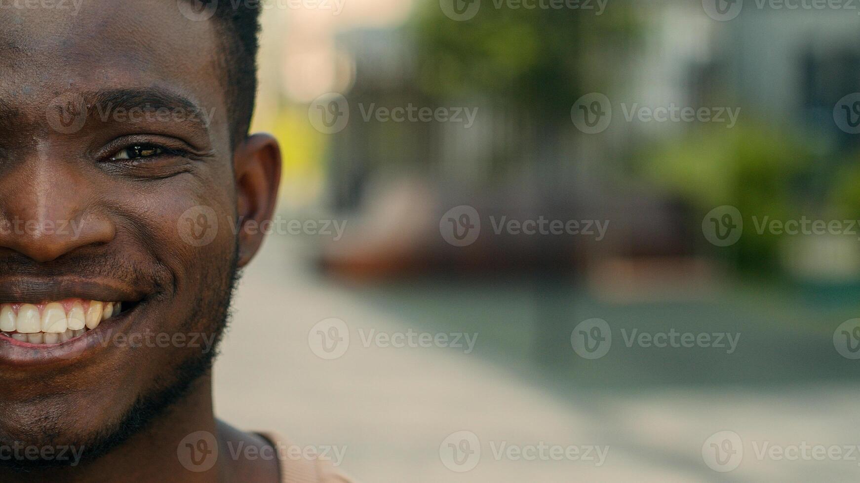 Close up half part face African American ethnic university student guy man businessman business employer posing in city outdoors smiling toothy laugh happy facial expression smile ad empty copy space photo