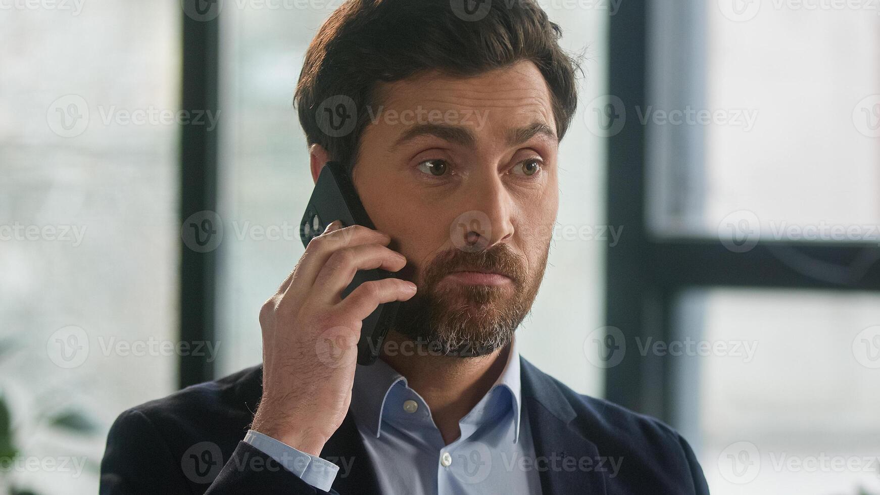 Close-up frustrated businessman aggressive loud talk on phone in office angry nervous man leader CEO discuss business problems on cellphone feel stress annoyed male has conflict speaking on smartphone photo
