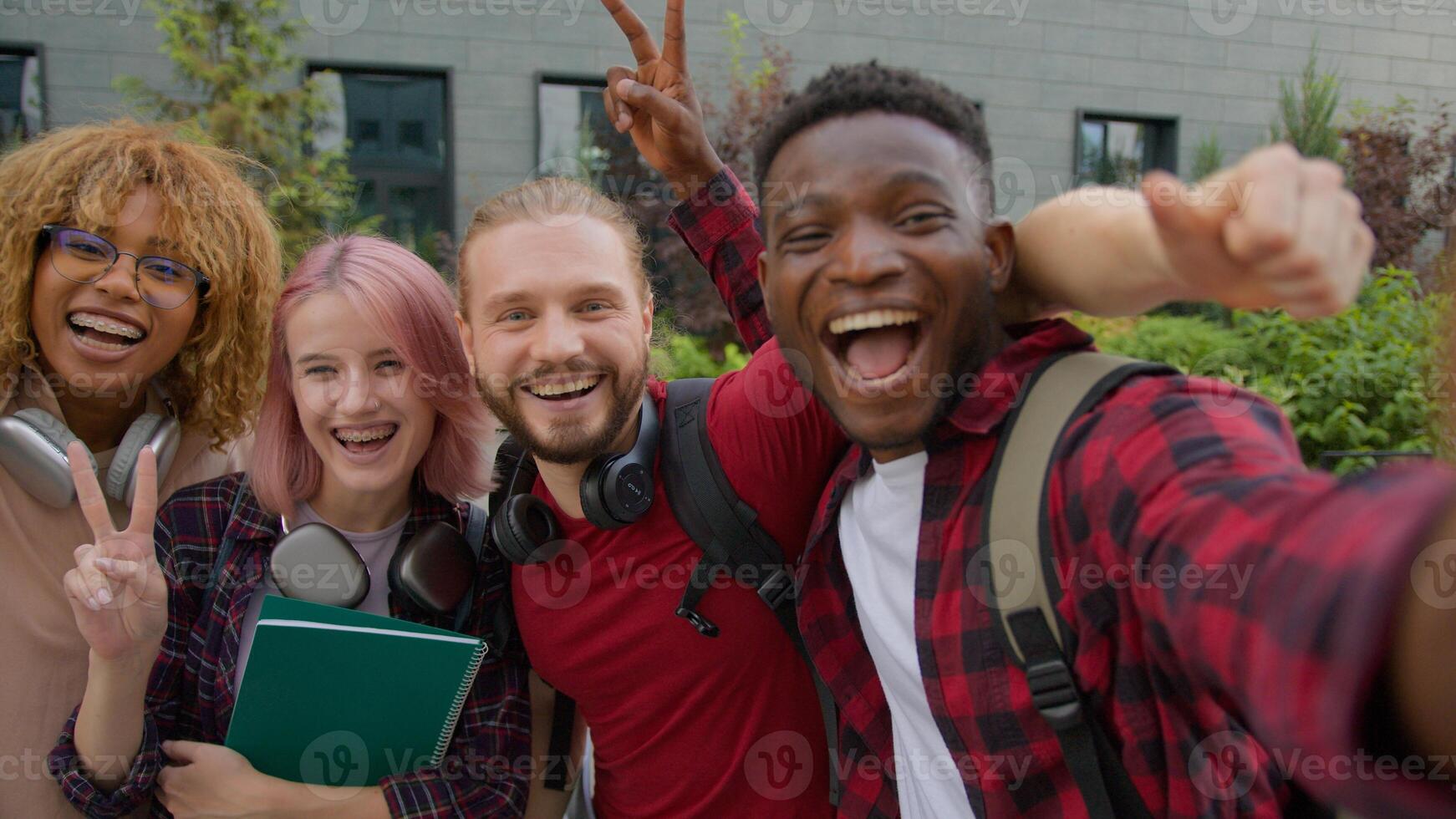 Diverse multiracial college university friends happy gen z multiethnic people teens students smiling record blog vlog influencer posing for selfie photo together for social media outdoors city