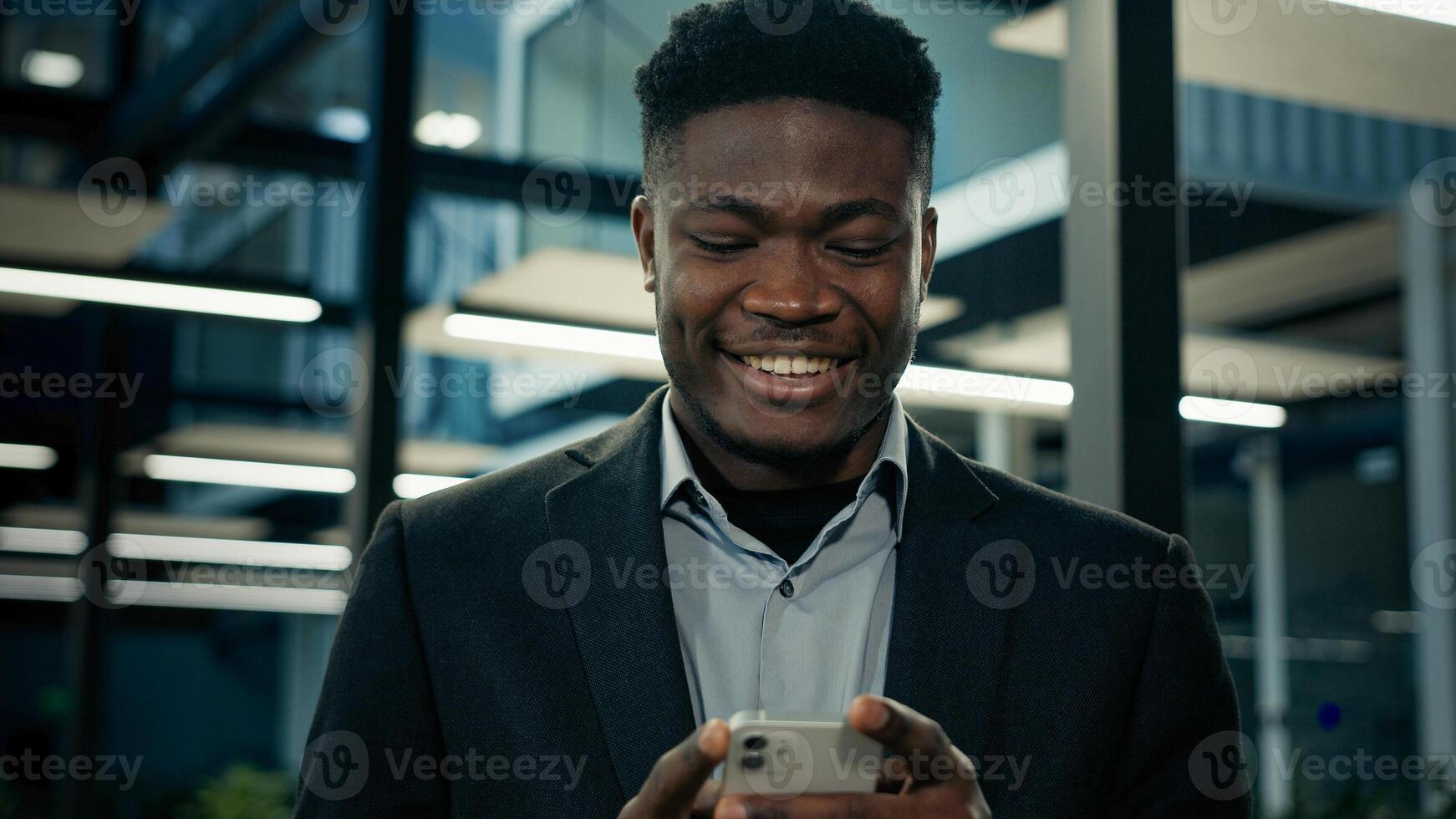 African businessman young male entrepreneur user executive worker employee ethnic man texting message on phone smiling read good mobile notification chatting online business chat cell communication photo