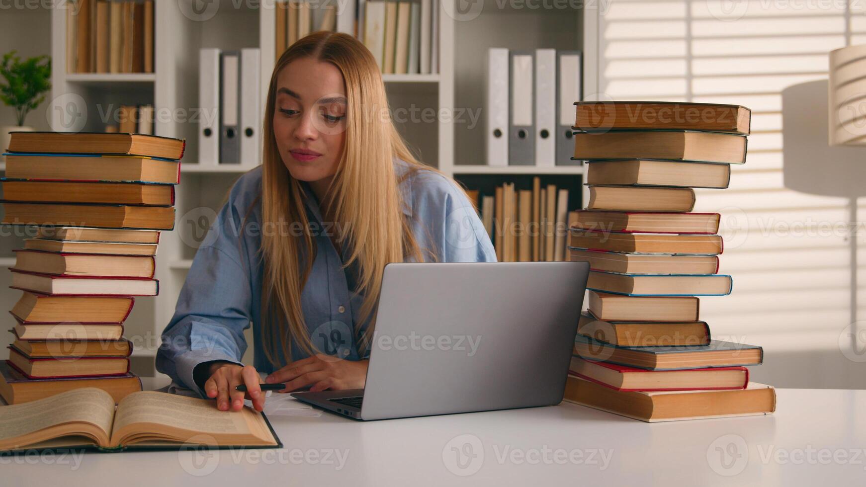 Caucasian student happy smiling girl woman studying with laptop and books homework learning online knowledge prepare for test exam study at library cram SAT test bookworm research history prep course photo