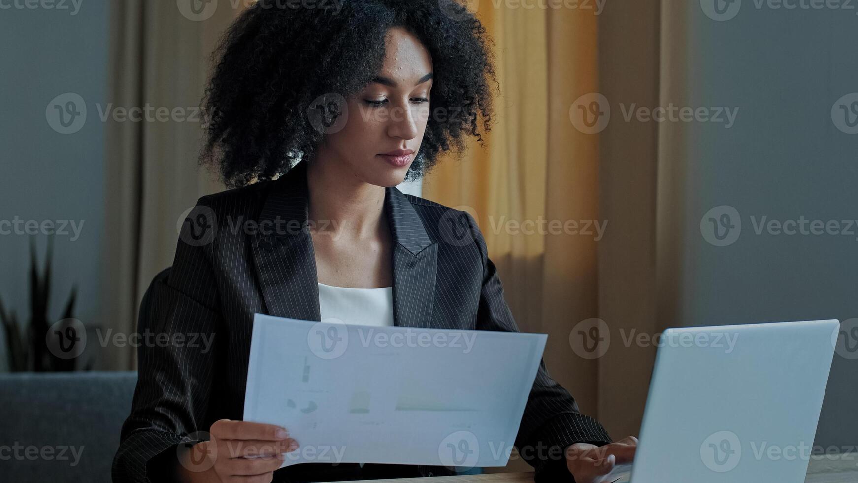 African teacher worker business woman work with graphics documents at home office check documentation enter financial data to laptop processing online information paying bills in computer banking app photo