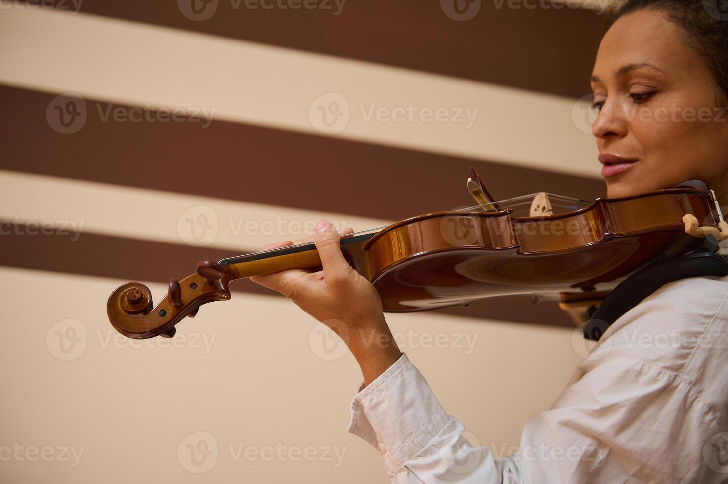 Woman playing classical violin in an elegant indoor setting photo