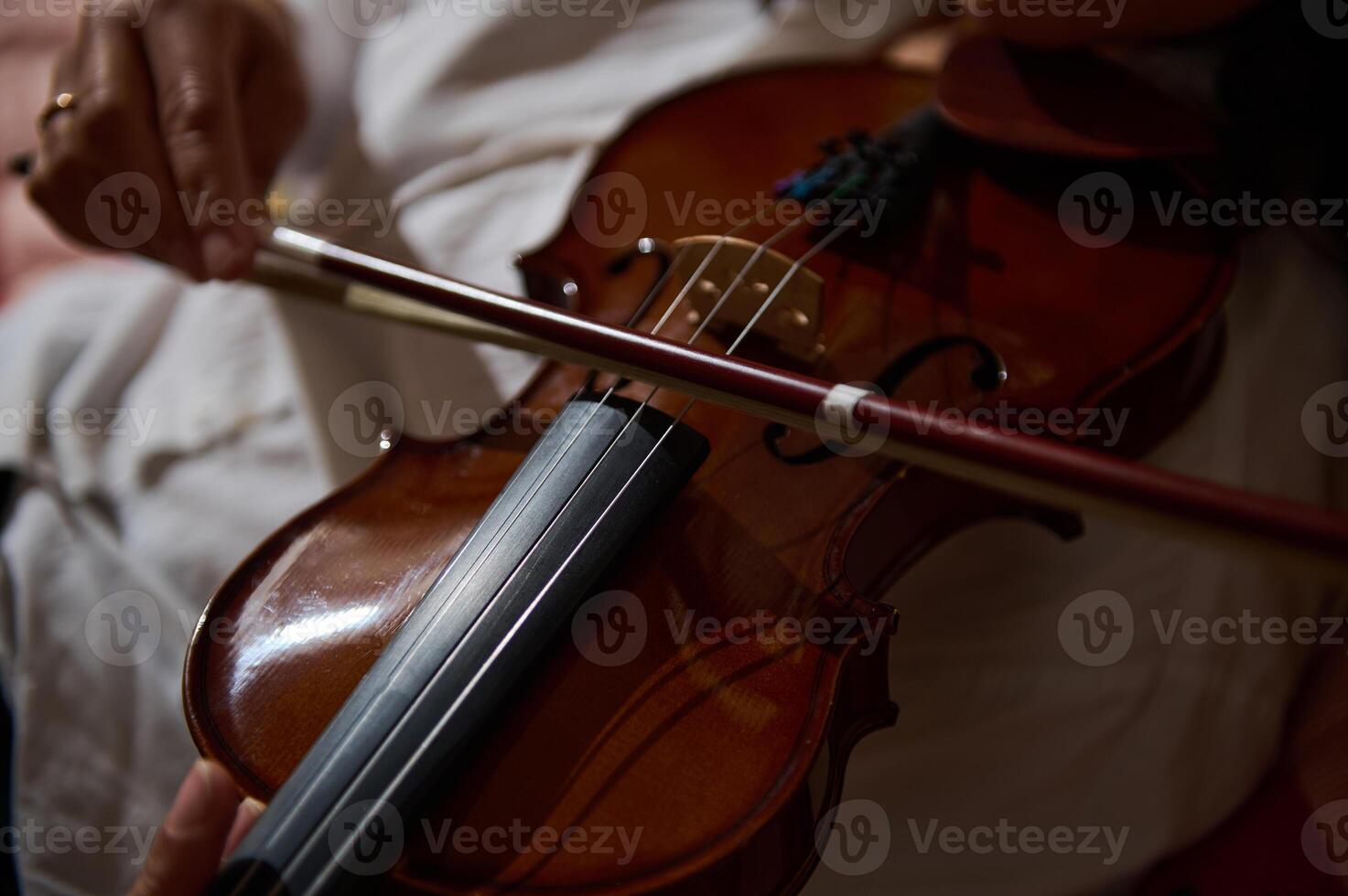 Close-up of a violin being played by a skilled musician indoors photo