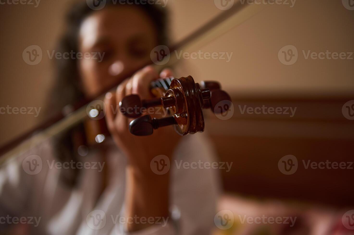 Close-up of a violinist playing music in warm cozy setting photo
