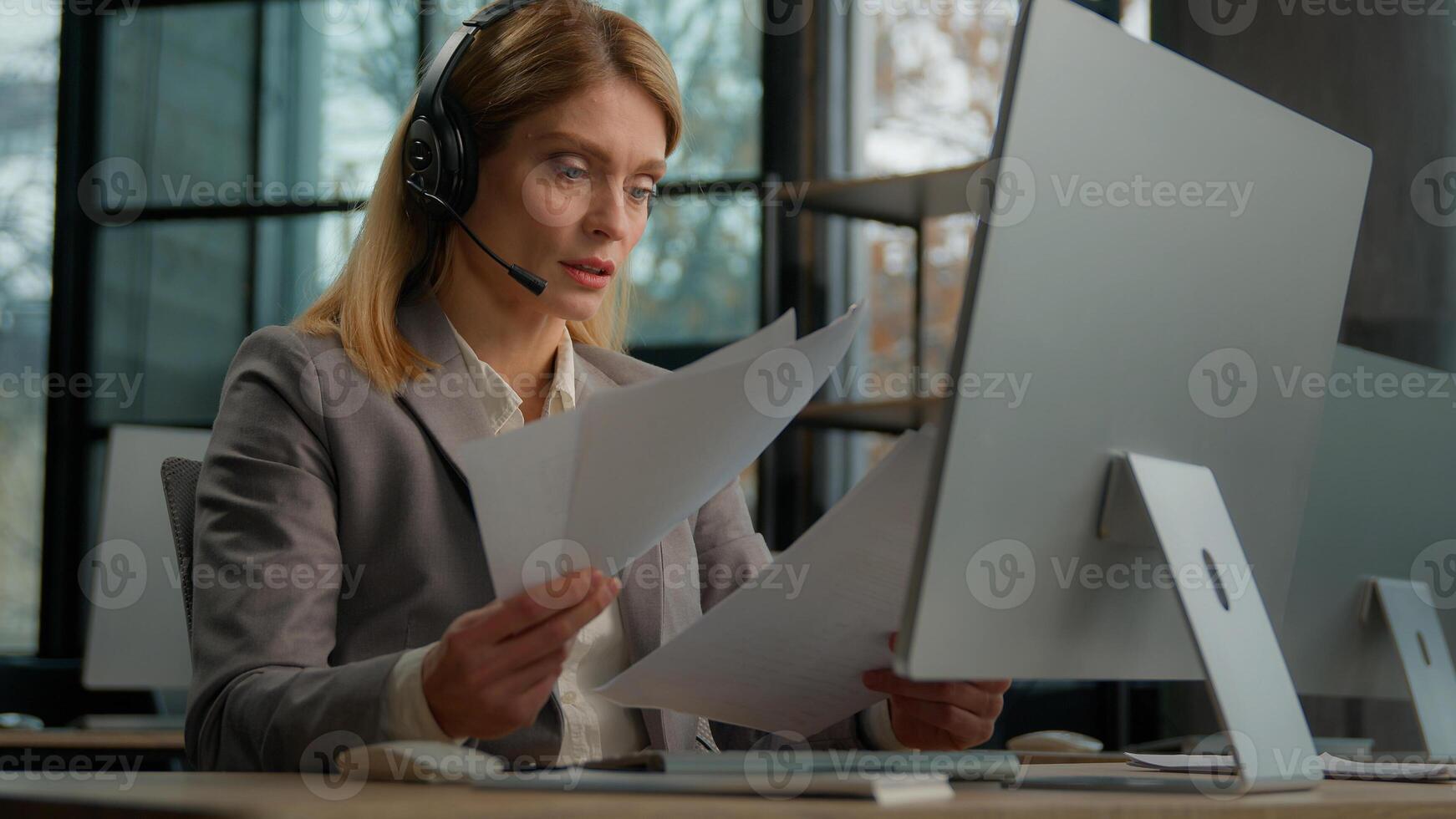 Call center female worker woman customer support service manager operator Caucasian businesswoman business coach with documents papers talking with headset call conference check report paperwork photo