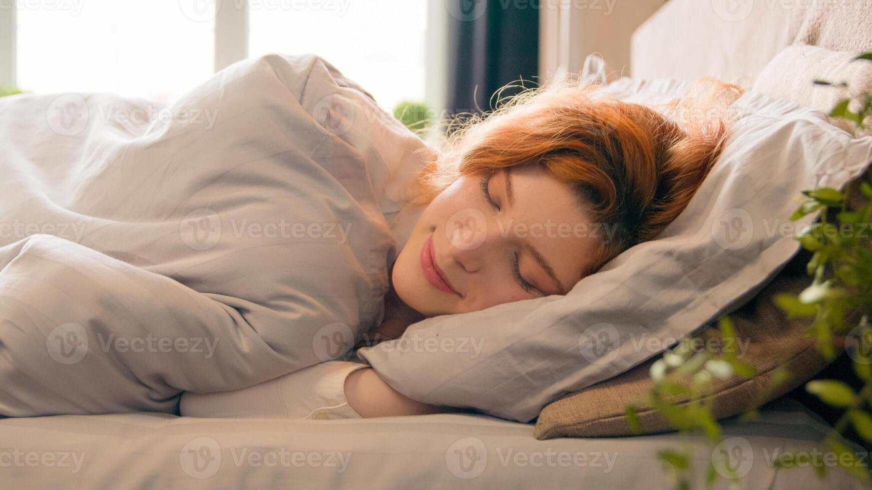 Caucasian happy woman sleeping in comfortable cozy bed at home girl lady asleep lying on soft pillow white linen orthopedic mattress resting relaxing napping healthy sleep nap in morning stress relief photo