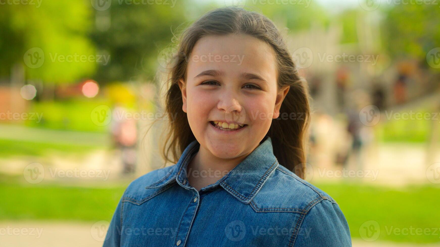 Portrait little kid Caucasian child happy positive emotion pretty schoolgirl teen pupil daughter adoption custody childcare medical insurance smile toothy girl joyful innocence face outdoors city park photo