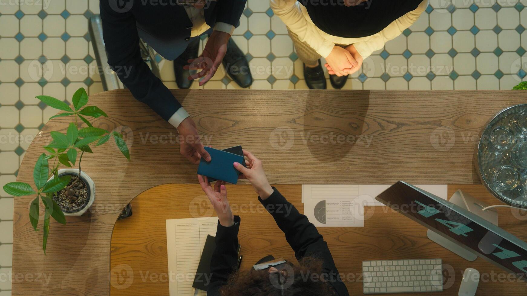 Top view concierge meet guests welcome hotel reception muslim couple tourists travelers arrive resort journey vacation travel abroad administrator check passports give key card booking room service photo