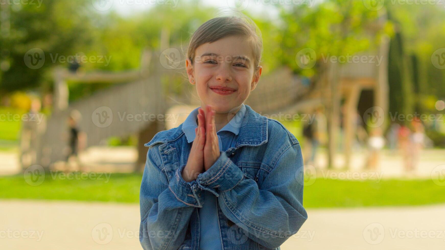 Outdoor portrait little kid Caucasian girl daughter schoolgirl pupil female teenager happy healthy smile adopt child student applaud clap hands applause rejoice have fun in park city custody childhood photo
