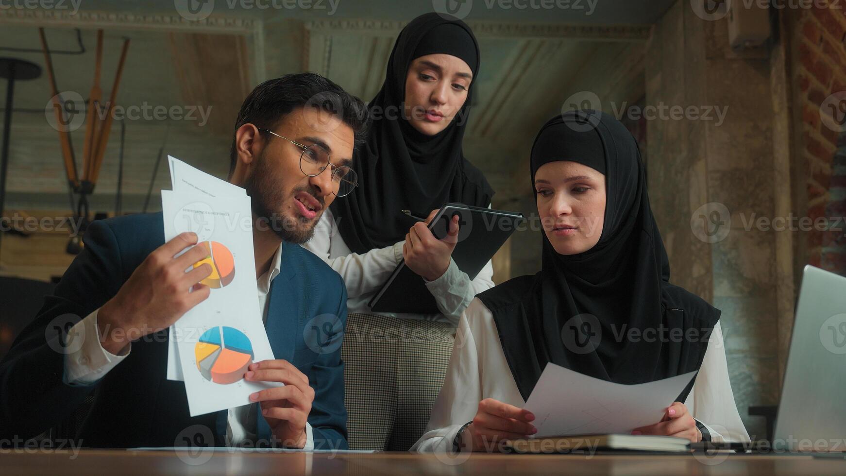 Arabian man talk online call laptop with client dissatisfied upset business male female office workers businessman businesswomen muslim women in hijab showing documents data graphs bad results photo