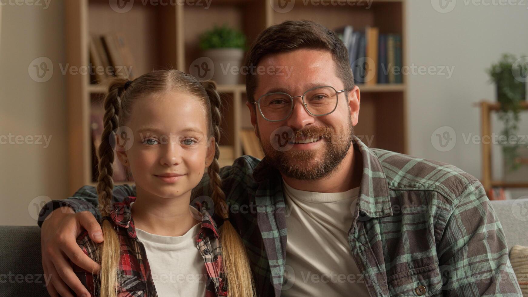 Happy family portrait smiling Caucasian dad father man hugging child girl at home cheerful male parent guy embracing little daughter custody kid enjoying weekend cuddle looking at camera parenthood photo