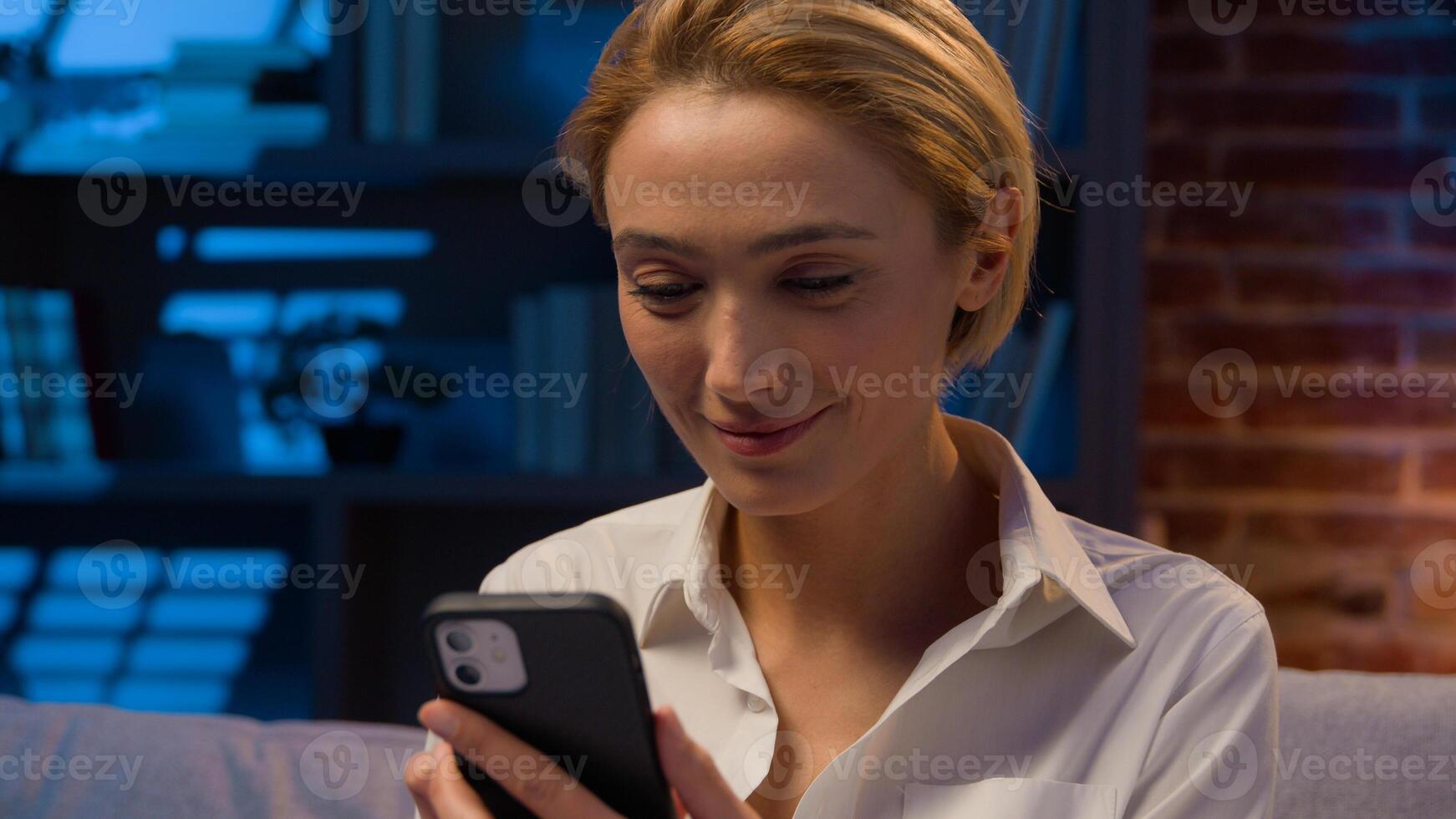 Gadget internet social media addict Caucasian woman at night evening home office scrolling mobile phone browsing internet service shopping online with smartphone businesswoman female using telephone photo